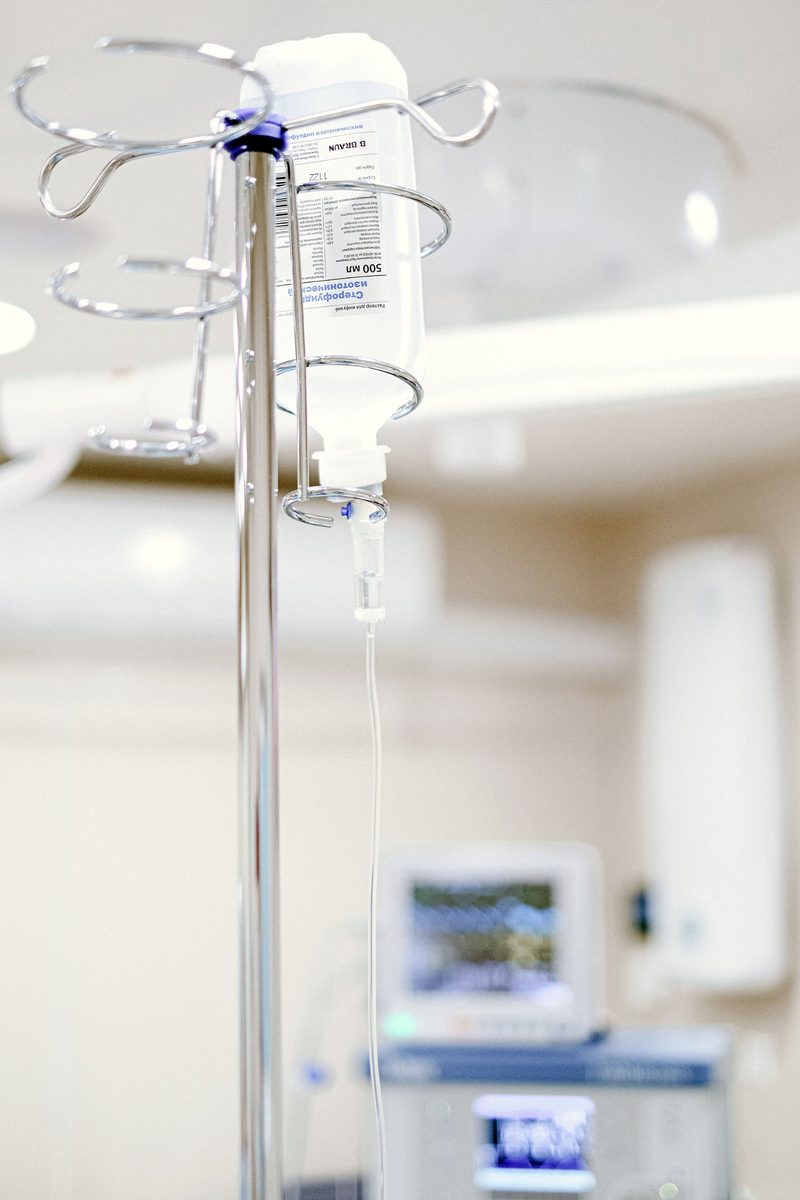 An intravenous drip bag and line hanging from a stand in a treatment room